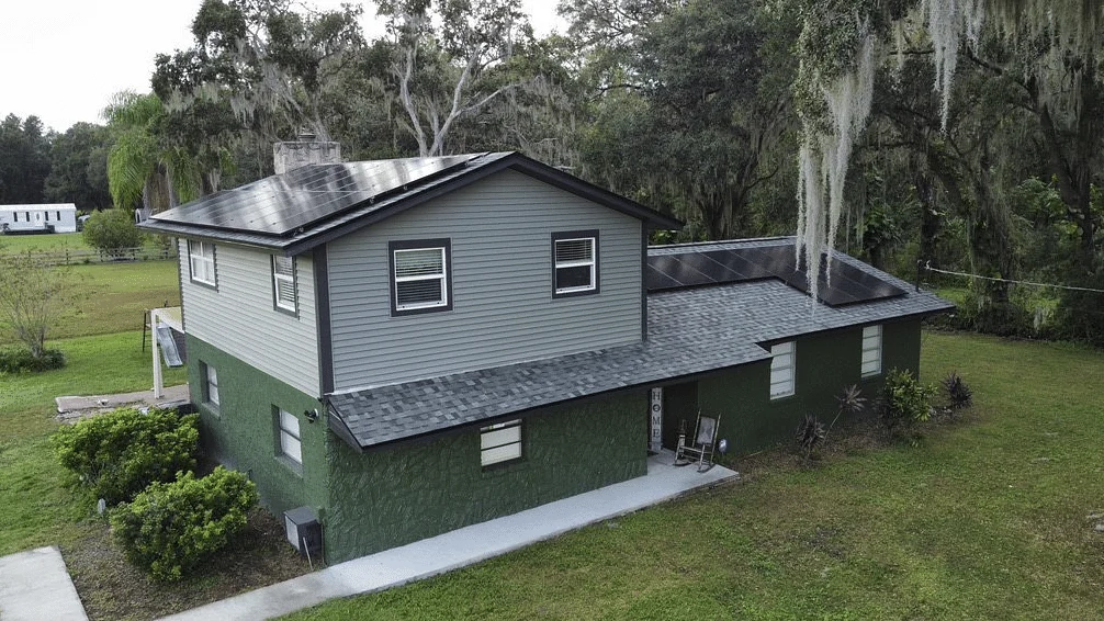 Greentek project photo — a drone view of a two-storey home under Spanish moss with solar panels covering both roof planes