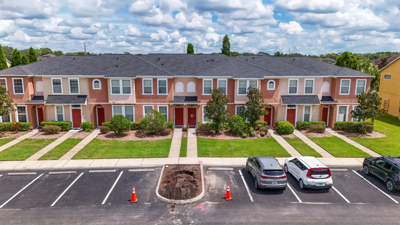 Greentek project photo — a row of Florida townhomes photographed from the car park after a full shingle re-roof
