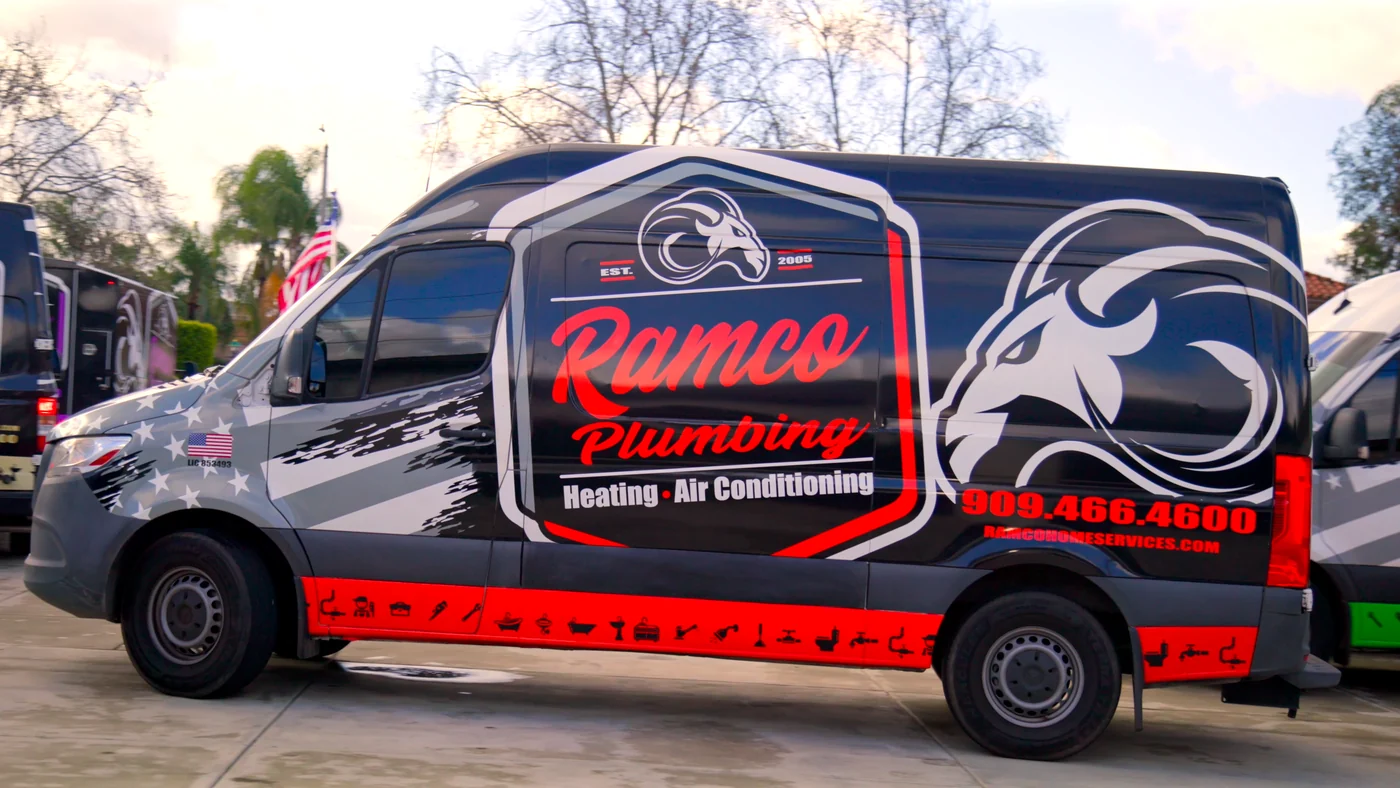 Ramco project photo — a Ramco Plumbing Sprinter van in the black, red and stars-and-stripes wrap, parked alongside the rest of the fleet